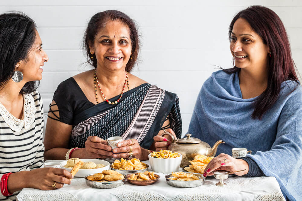 Mother and daughter enjoying chai with Gujarati snacks